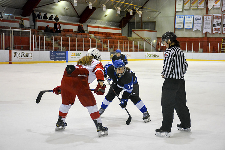 Two female hockey players prepare to face off