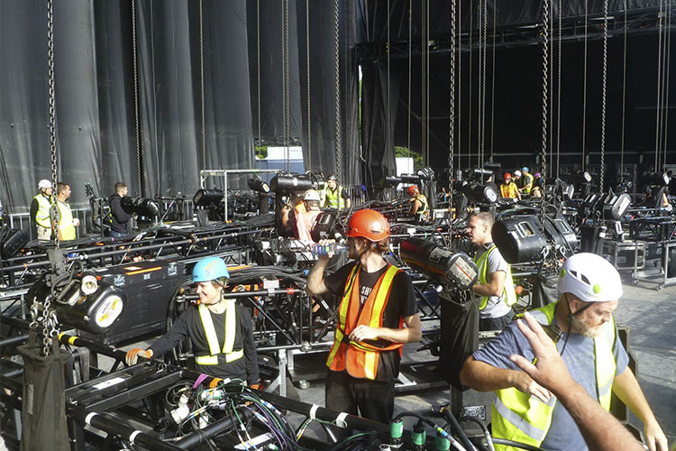 A large group of stage workers leading up to a music event