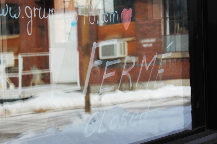 Window of a Montreal restaurant with the word Ferme closed during the pandemic