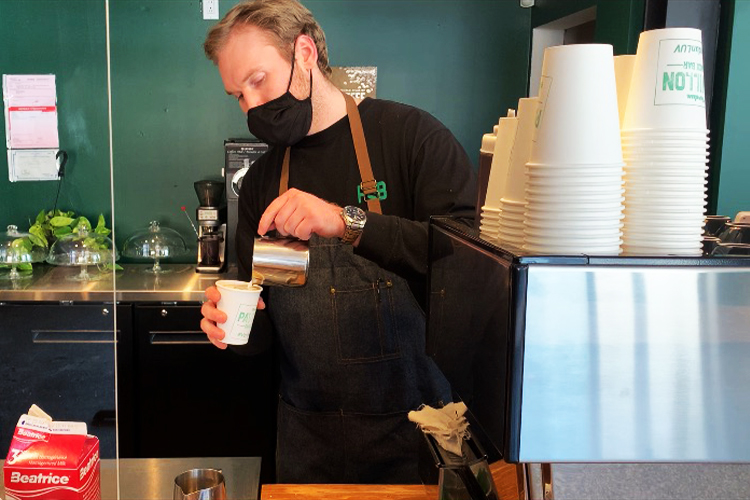 A barista pouring a coffee