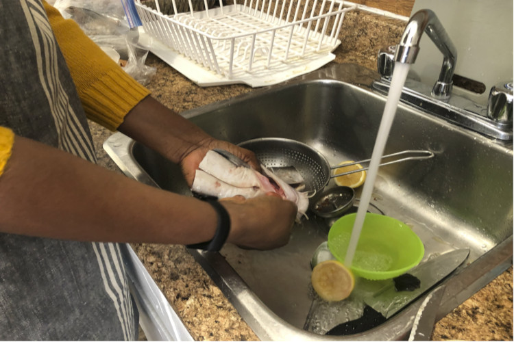 Oyeyemi Oshadipe washing fish in her home business kitchen