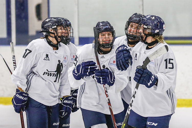 Emily Clark celebrates a goal with her teammates during a women's hockey game