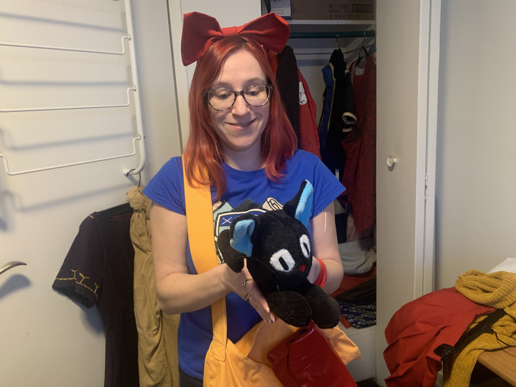 Red-haired woman holds a black cat plush