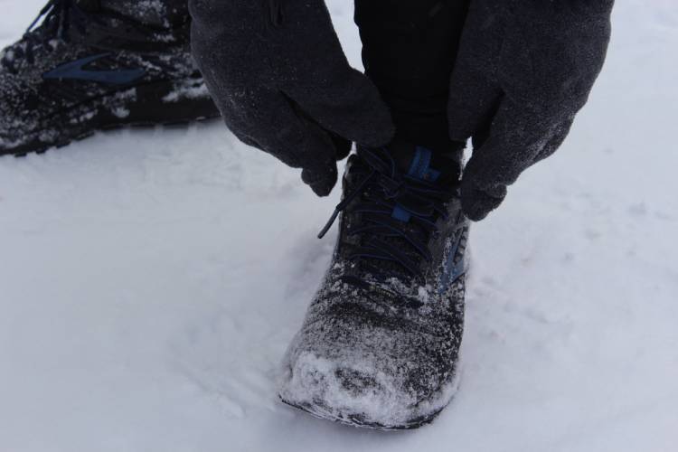 Runner tying his shoe in the snow