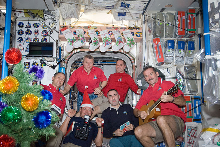 Crewmembers from Expedition 34 celebrate Christmas on the ISS. Pictured clockwise (from top right) are NASA astronaut Kevin Ford, commander; Canadian Space Agency astronaut Chris Hadfield, Russian cosmonauts Evgeny Tarelkin and Roman Romanenko, NASA astronaut Tom Marshburn and Russian cosmonaut Oleg Novitskiy, all flight engineers