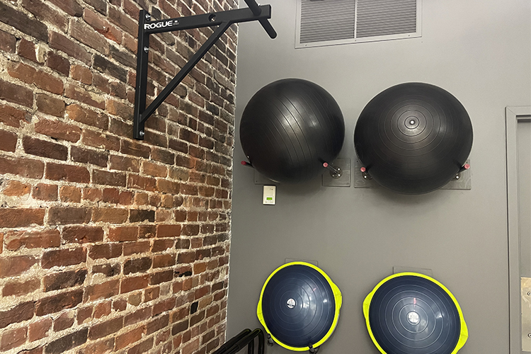 One of the Silofit private workout spaces where gym equipment hangs on the wall.