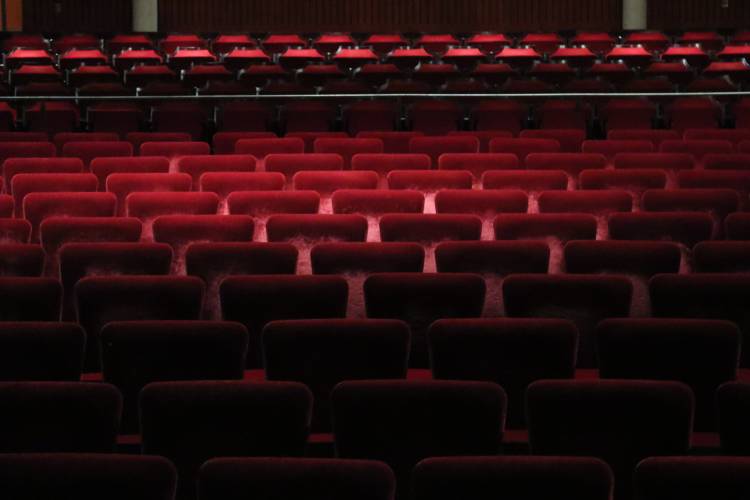 Empty theatre room with red seats.