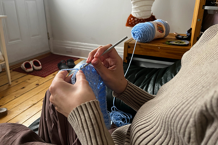 A close up of Lopez crocheting