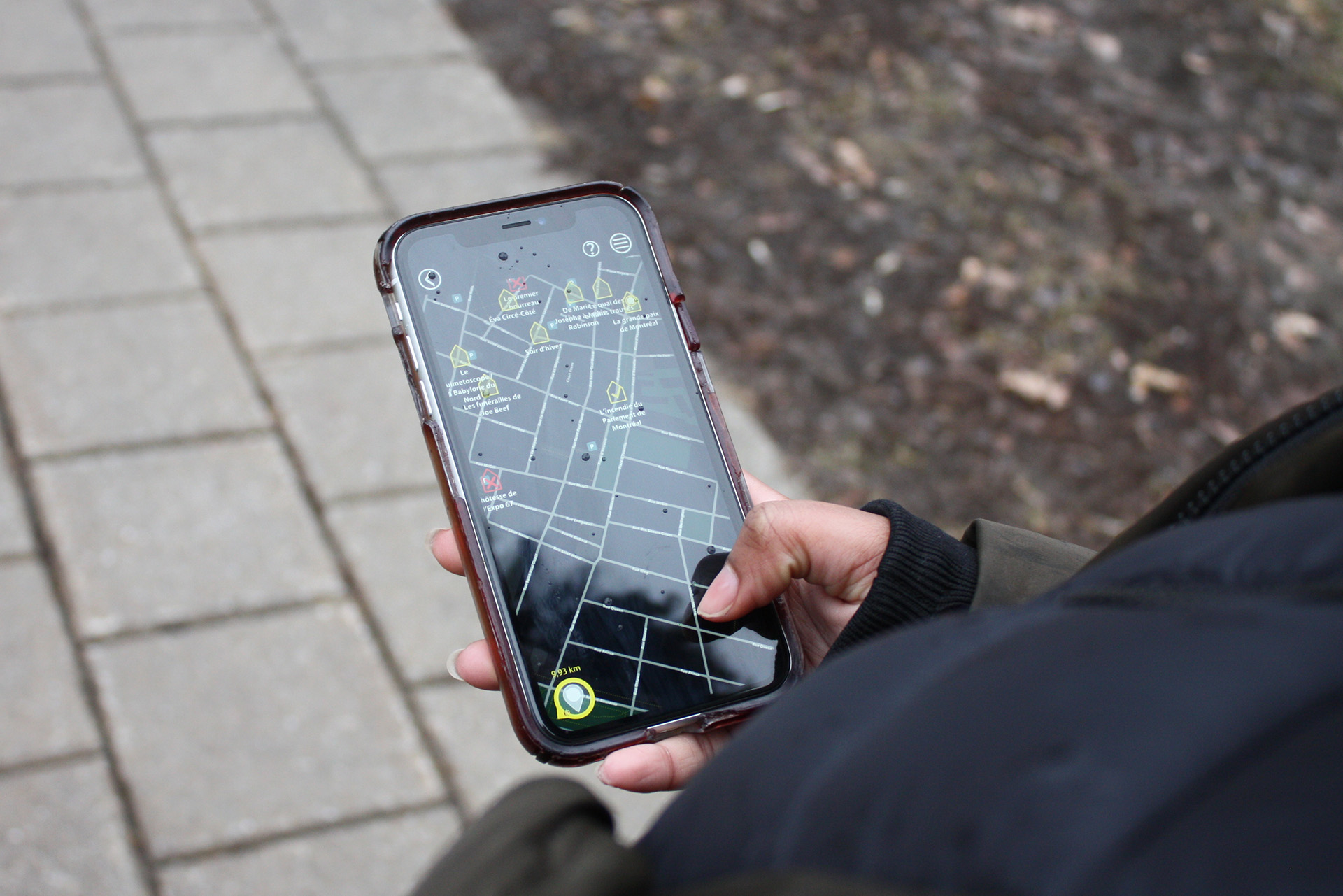 A mobile phone with the Montréal en Histoires app GPS open.