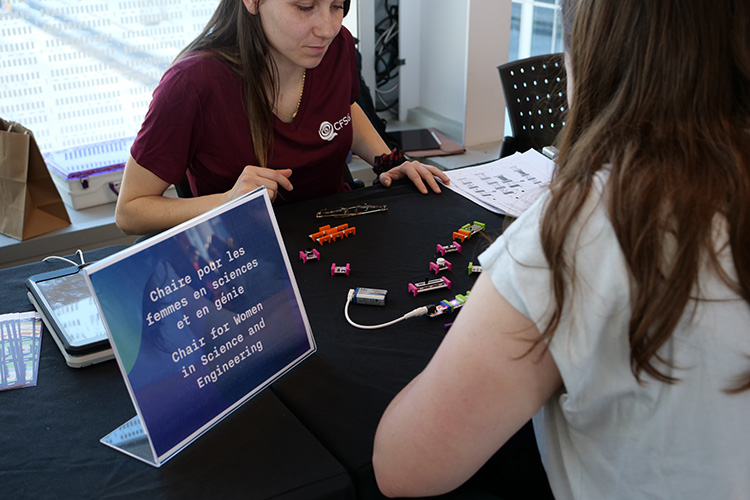 A researcher from the Chair for Women in Science and Engineering of Quebec is doing an activity with a visitor at the Women and Girls of Science event at the Montreal Science Center. Photo by Maggy McDonald.