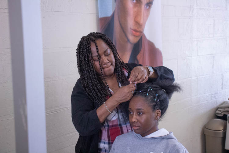 Bearnardez actively styling one of her clients' hair, Florence Ojo.