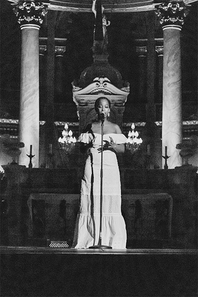 girl in a formal dress reciting a poem on a stage