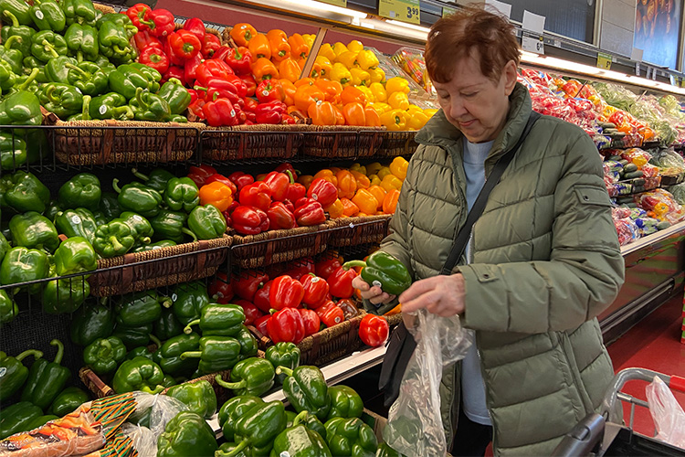 Maisie Milstein examines a pepper at the grocery store.