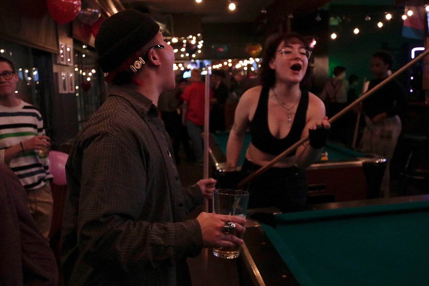 Two people playing pool in a bar