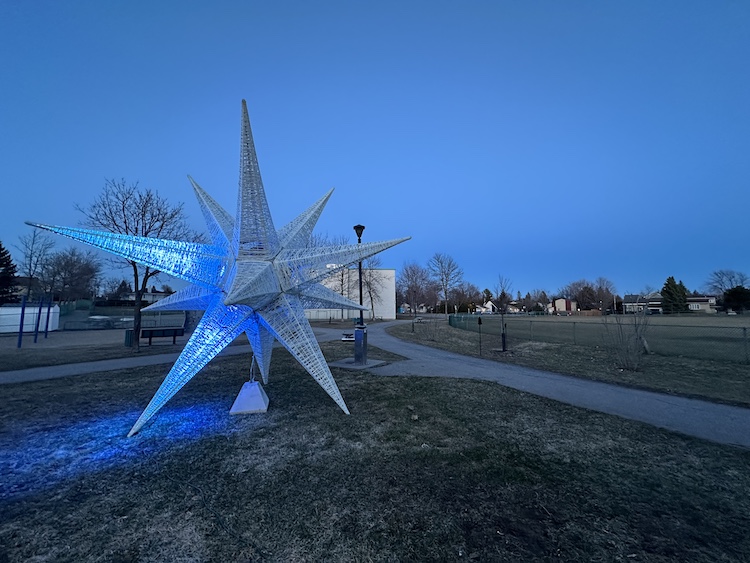 A star shaped art piece has only two legs illuminated rather than ten.